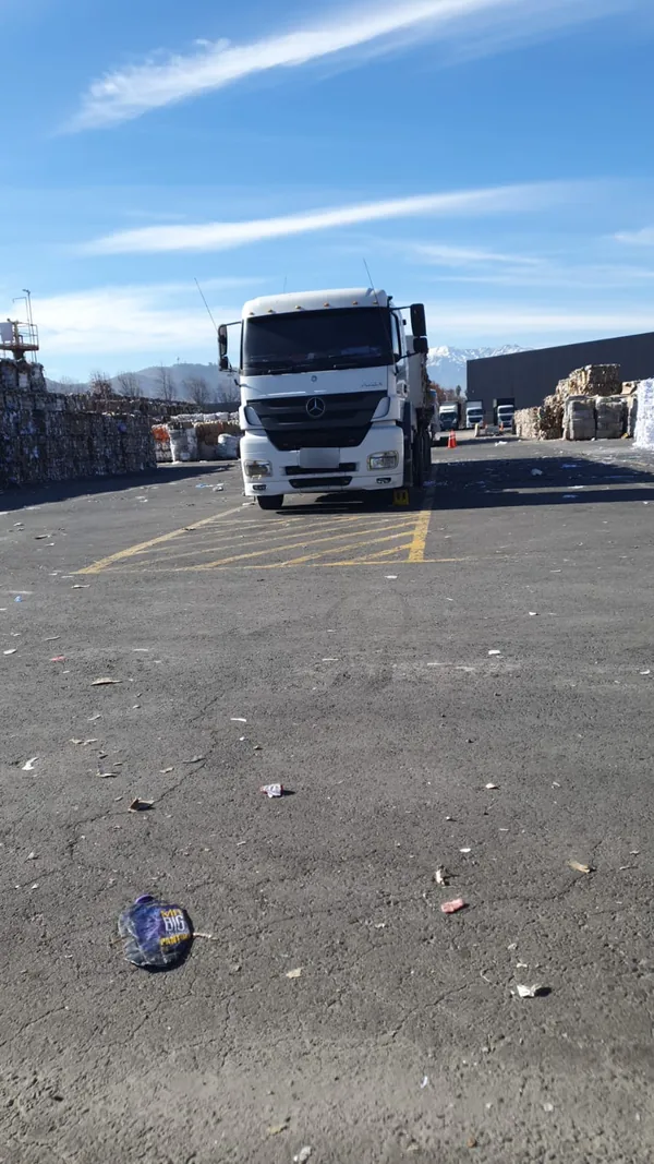 Tractocamión Mercedes-Benz blanco en patio de acopio de fardos